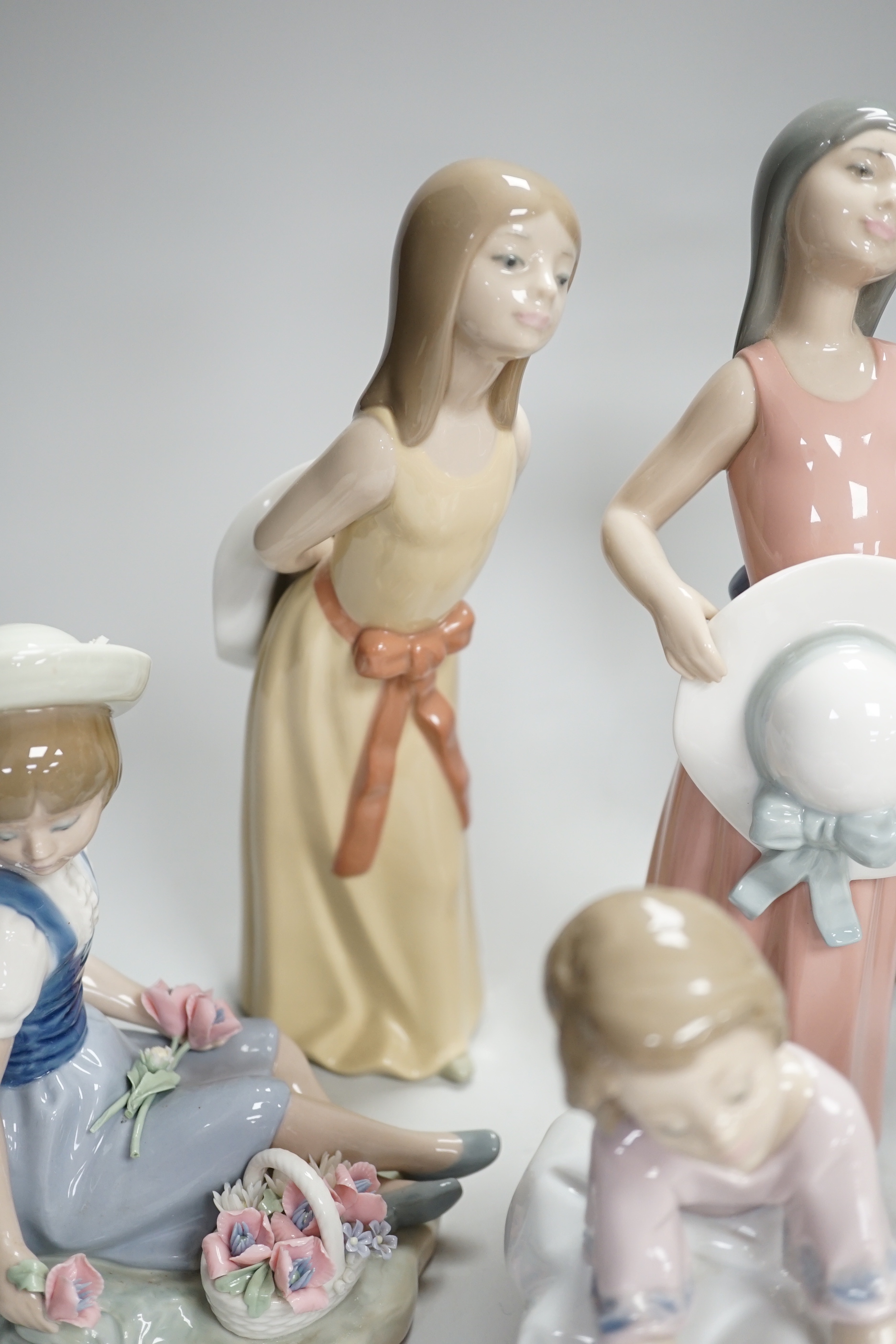 Six Lladro figures of girls, three with hats, one with a Teddy, two peasant girls with flowers and two Nao ducks, the largest 26cm high (8)